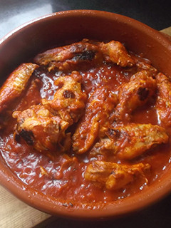 Una foto de Alitas de pollo con tomate y cebolla