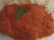 Una foto de bacalao con tomate y pimientos rojos
