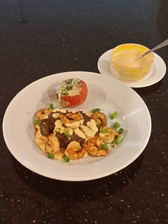 A picture of Seared Steak and Shrimp with Sriracha Hollindaise and Roasted Tomatoes.