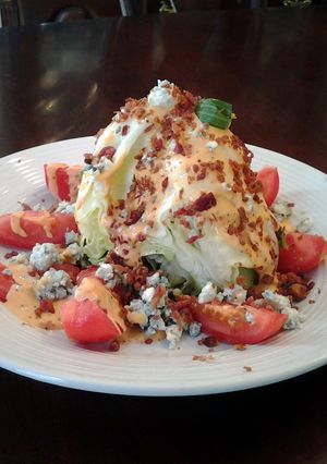 A picture of BLT Wedge Salad With Blue cheese and Homemade Zesty Russian Dressing.
