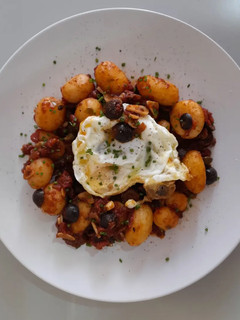 Una foto de Patatas a la puttanesca con huevo frito