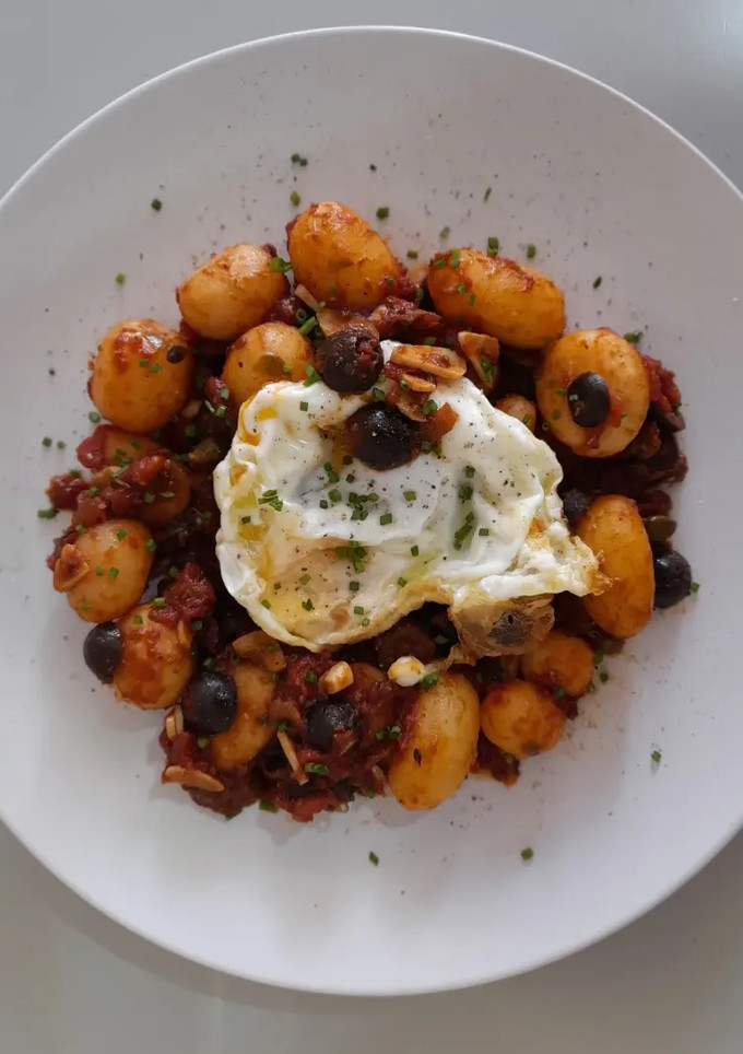 Una foto de Patatas a la puttanesca con huevo frito