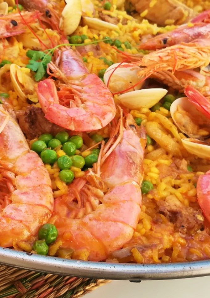 Una foto de Paella mixta de conejo y marisco en barbacoa