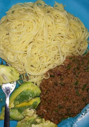 A picture of Minced meat and spaghetti. Served with avocado.