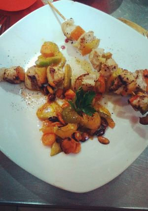Una foto de Brochetas de pollo con una guarnición de vegetales y maní