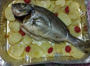 Una foto di orata al forno con patate