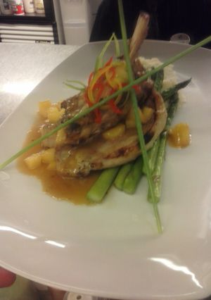 A picture of Brined pork chop with captain morgan apple demiglaze mashed potatoes and asparagus.