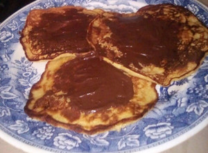 Una foto de Tortitas de banano cubiertas de chocolate. (panqueques)