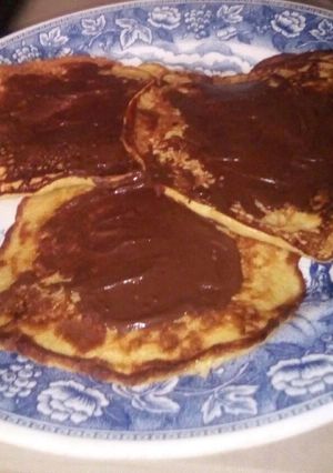 Una foto de Tortitas de banano cubiertas de chocolate. (panqueques)