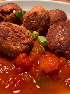 Una foto de Albóndigas de garbanzos y quinoa en “fritá” de tomates