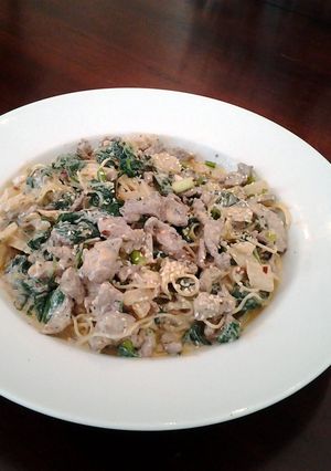 A picture of beef noodles with spinach and coconut/curry vinaigrette.