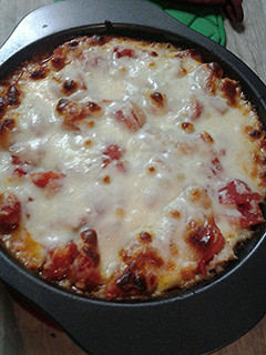 A picture of Cheesy, tomato ,and rice with a little meat pie.
