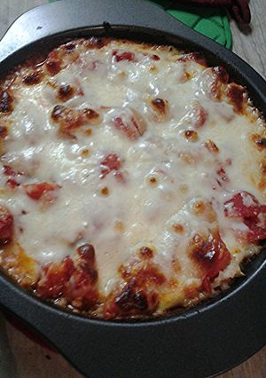 A picture of Cheesy, tomato ,and rice with a little meat pie.