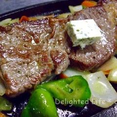 A picture of Beef Steak with Lots of Veggies.