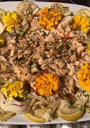 Une photo de Salade castelfranco au saumon citron confit et fleurs comestibles sauce balsamique