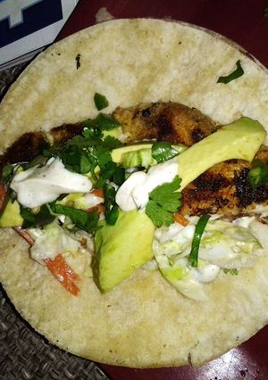 A picture of Fish taco with spicy cilantro lime sauce.