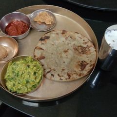 A picture of Kathiyawadi spoon Baingan Bharta with bajre rotla.