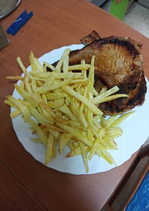 Una foto de Chuletas lacadas a la barbacoa con papas fritas