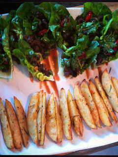 A picture of Chilli beef in lettuce cups with roast potato wedges.