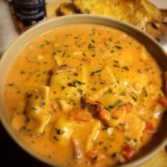 A picture of Creamy Tomato Soup with Chicken & Garlic Ravioli.