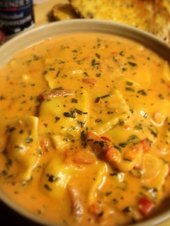 A picture of Creamy Tomato Soup with Chicken & Garlic Ravioli.