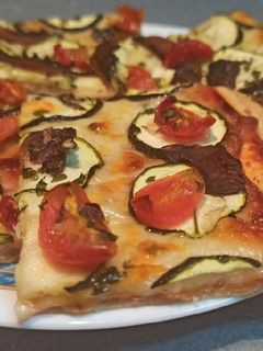 Una foto de Pizza de calabacín, champiñones y tomates cherry