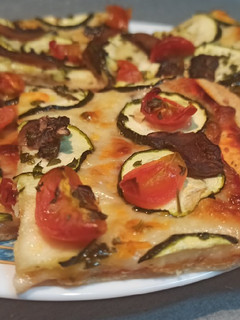 Una foto de Pizza de calabacín, champiñones y tomates cherry