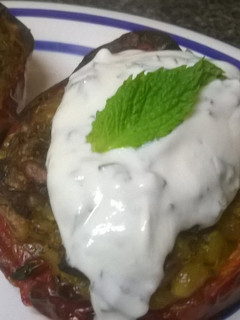 A picture of Rice stuffed peppers with mint yogurt sauce.