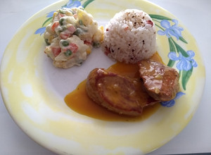 Una foto de Solomillo a la naranja con ensalada rusa y arroz con ajonjolí