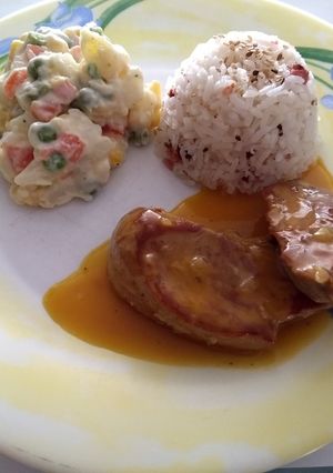 Una foto de Solomillo a la naranja con ensalada rusa y arroz con ajonjolí