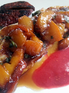 A picture of French toast and caramelized peaches with raspberry sauce.