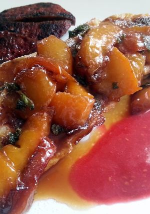 A picture of French toast and caramelized peaches with raspberry sauce.