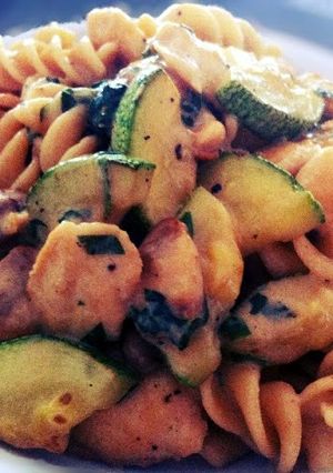 A picture of Fusilli pasta with chicken, mushroom and zucchini.