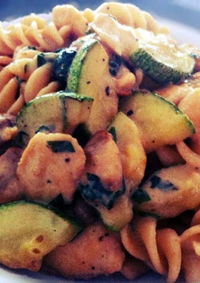 A picture of Fusilli pasta with chicken, mushroom and zucchini.