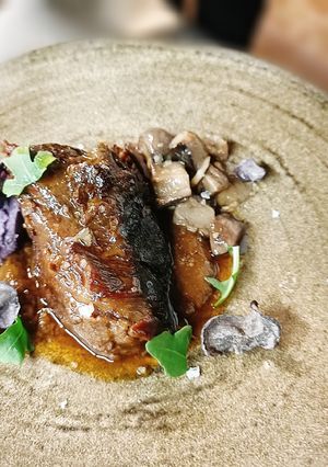 Una foto de Carrilleras con mole, Robüchon de patata violeta y hongos