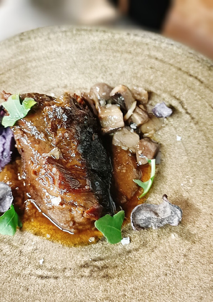 Una foto de Carrilleras con mole, Robüchon de patata violeta y hongos
