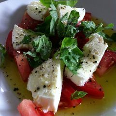 A picture of Bocconcini ,fresh tomato , & basil salad.