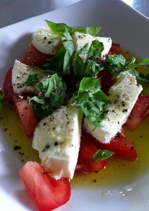 A picture of Bocconcini ,fresh tomato , & basil salad.