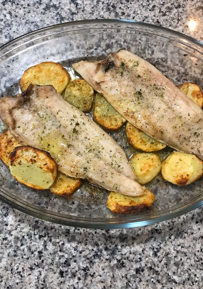 Una foto de Lubina al horno con patatas panaderas