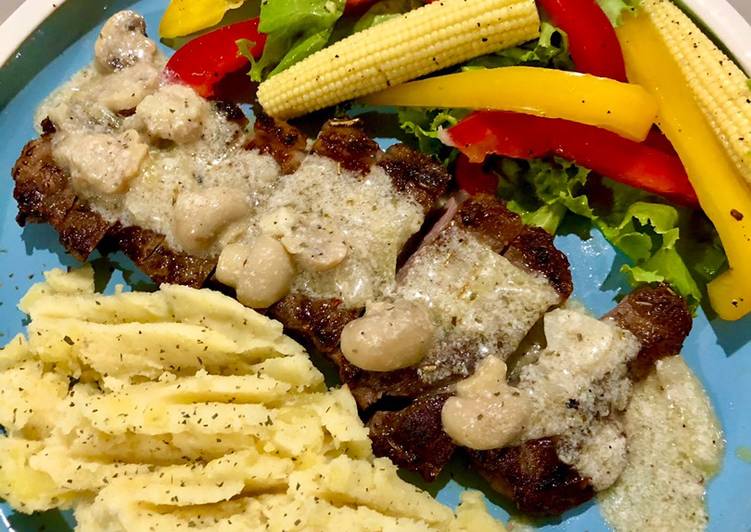 Beef steak with mushroom sauce, mashed potato and simple salad