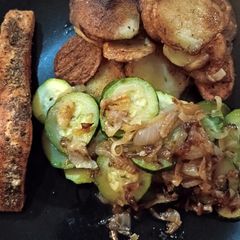 A picture of Salmon fillet with persillade potatoes, courgettes and onion.