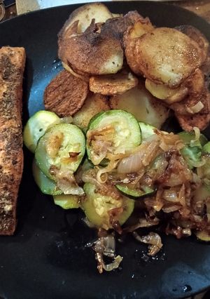 A picture of Salmon fillet with persillade potatoes, courgettes and onion.