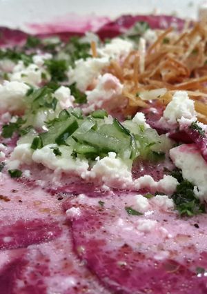 A picture of Beetroot carpaccio with goat cheese.