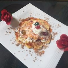 A picture of Waffles and ice cream with berry sauce and cator sugar.