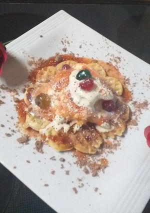 A picture of Waffles and ice cream with berry sauce and cator sugar.