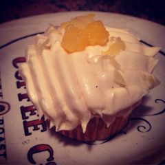 A picture of Pineapple & Coconut Cupcake W/ Coconut Frosting & Pineapple Shredding On Top.