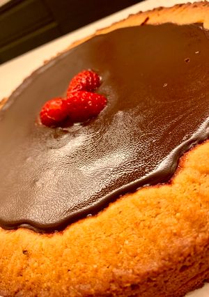 Foto di Crostata di nocciole con confettura di fragole ricoperta da ganache al cioccolato