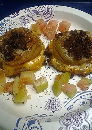A picture of Green tomatoes atop sausage.