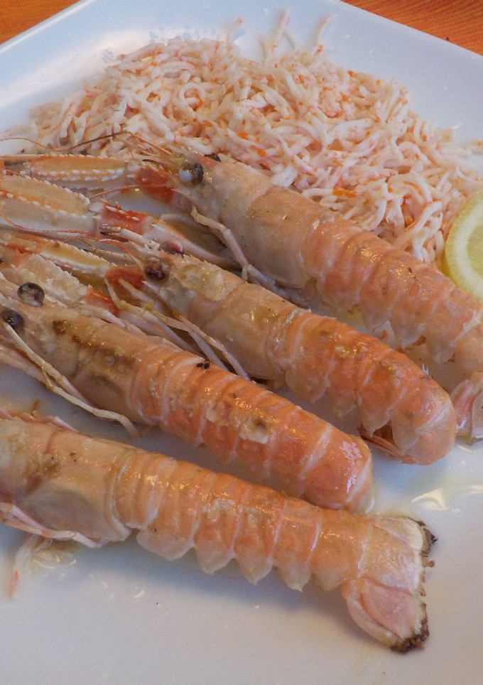 Una foto de Cigalas a la plancha con guarnición de surimi