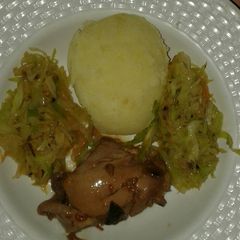 A picture of Mashed potatoes with fried cabbage & stewed chiken.